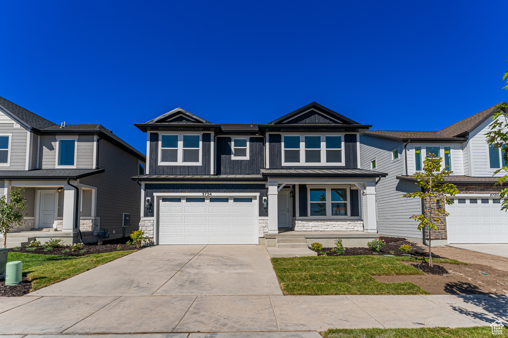 View of front of property with a garage and a front lawn