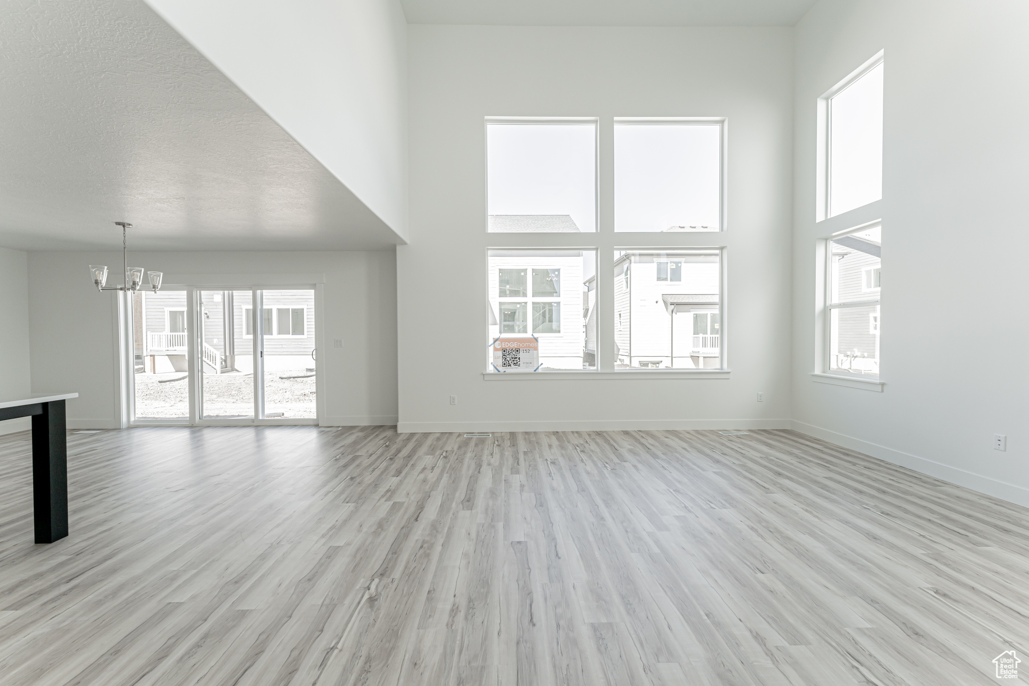 Unfurnished living room with light wood-type flooring, a high ceiling, and plenty of natural light