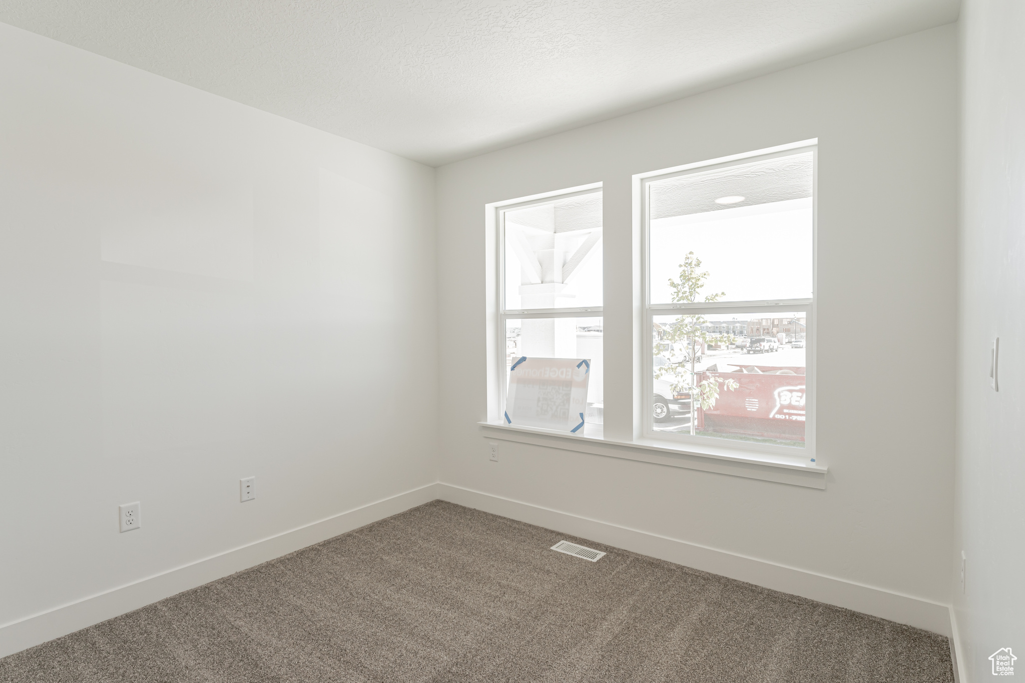 Carpeted empty room with a textured ceiling