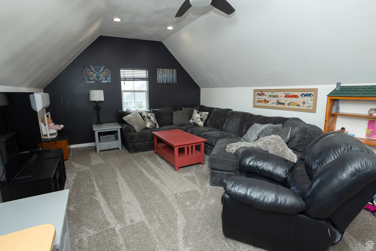 Living room featuring carpet, ceiling fan, and vaulted ceiling