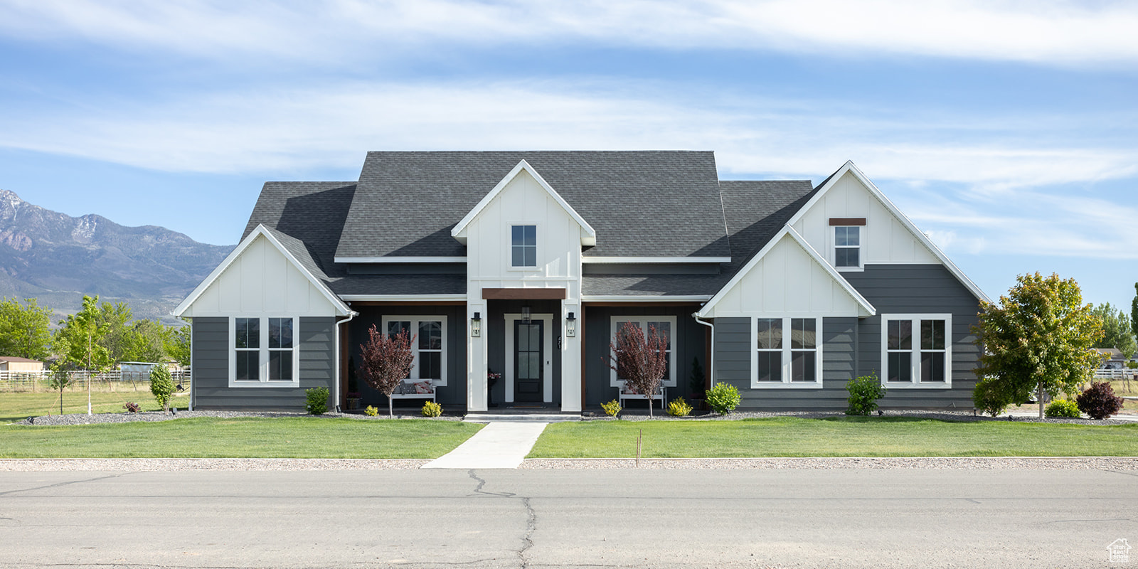 Modern farmhouse style home with a front yard and a mountain view