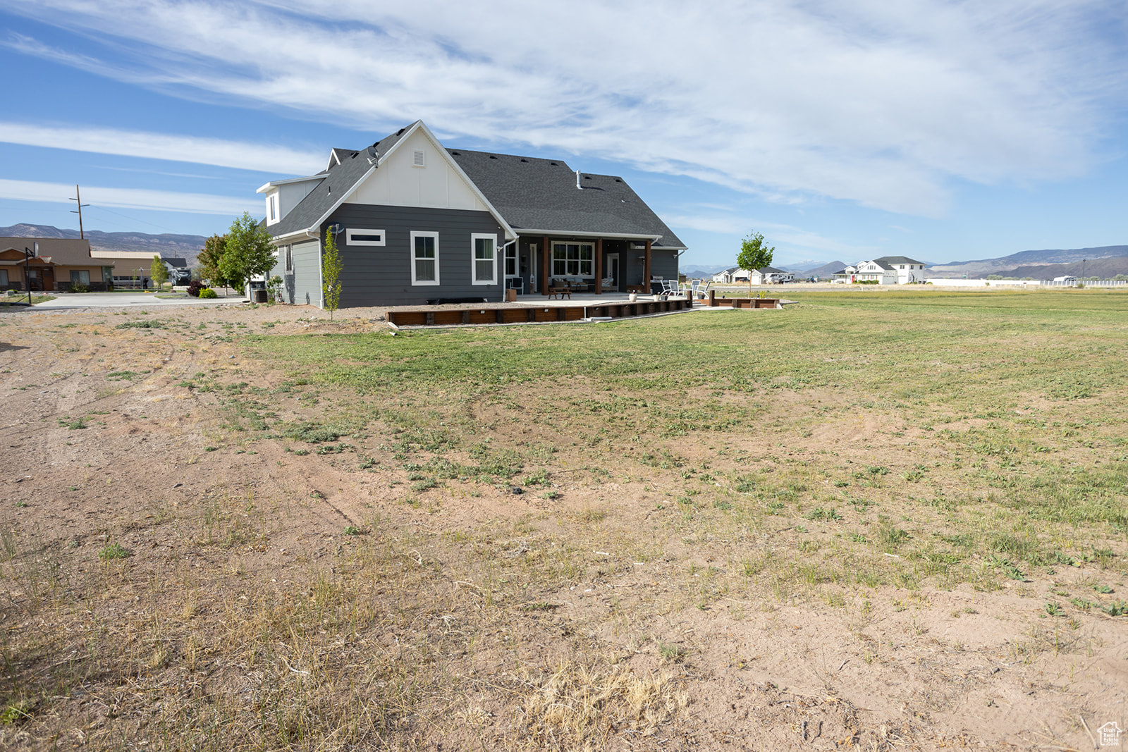 Back of property with a wooden deck and a lawn