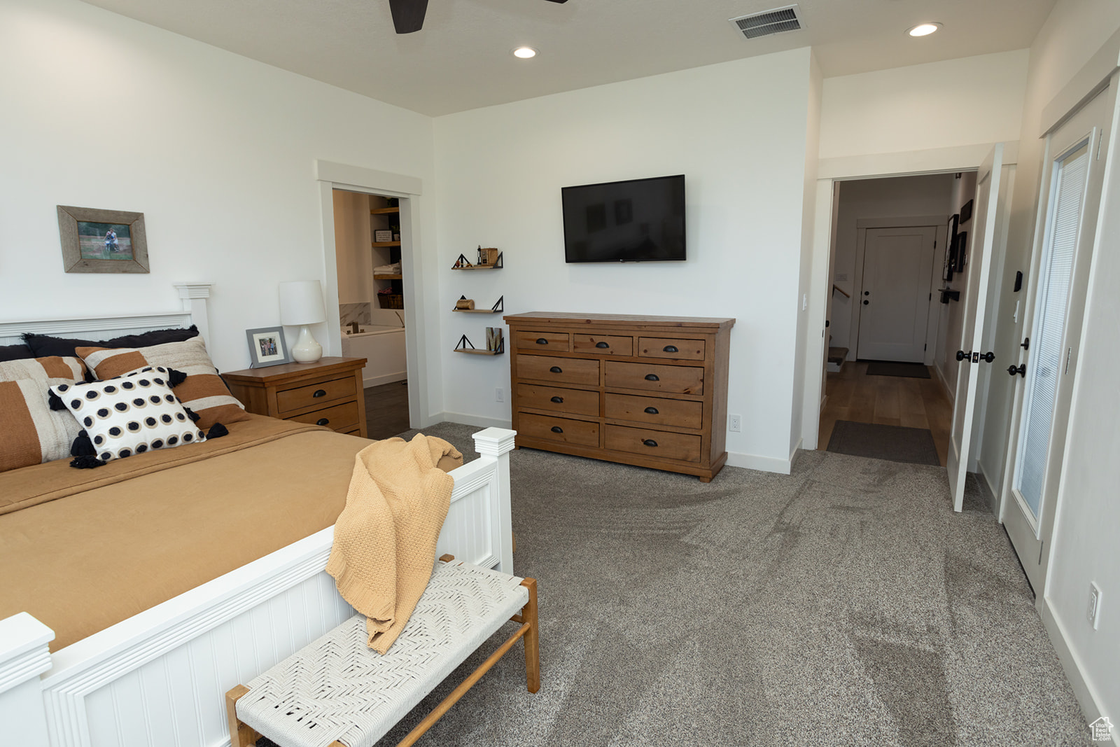 Bedroom featuring ensuite bathroom, carpet, and ceiling fan