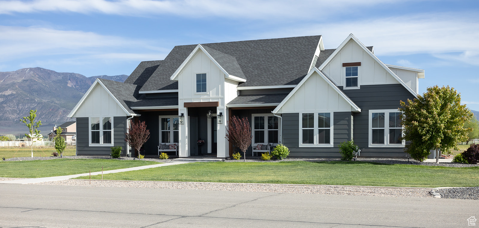 Modern farmhouse style home featuring a front yard and a mountain view