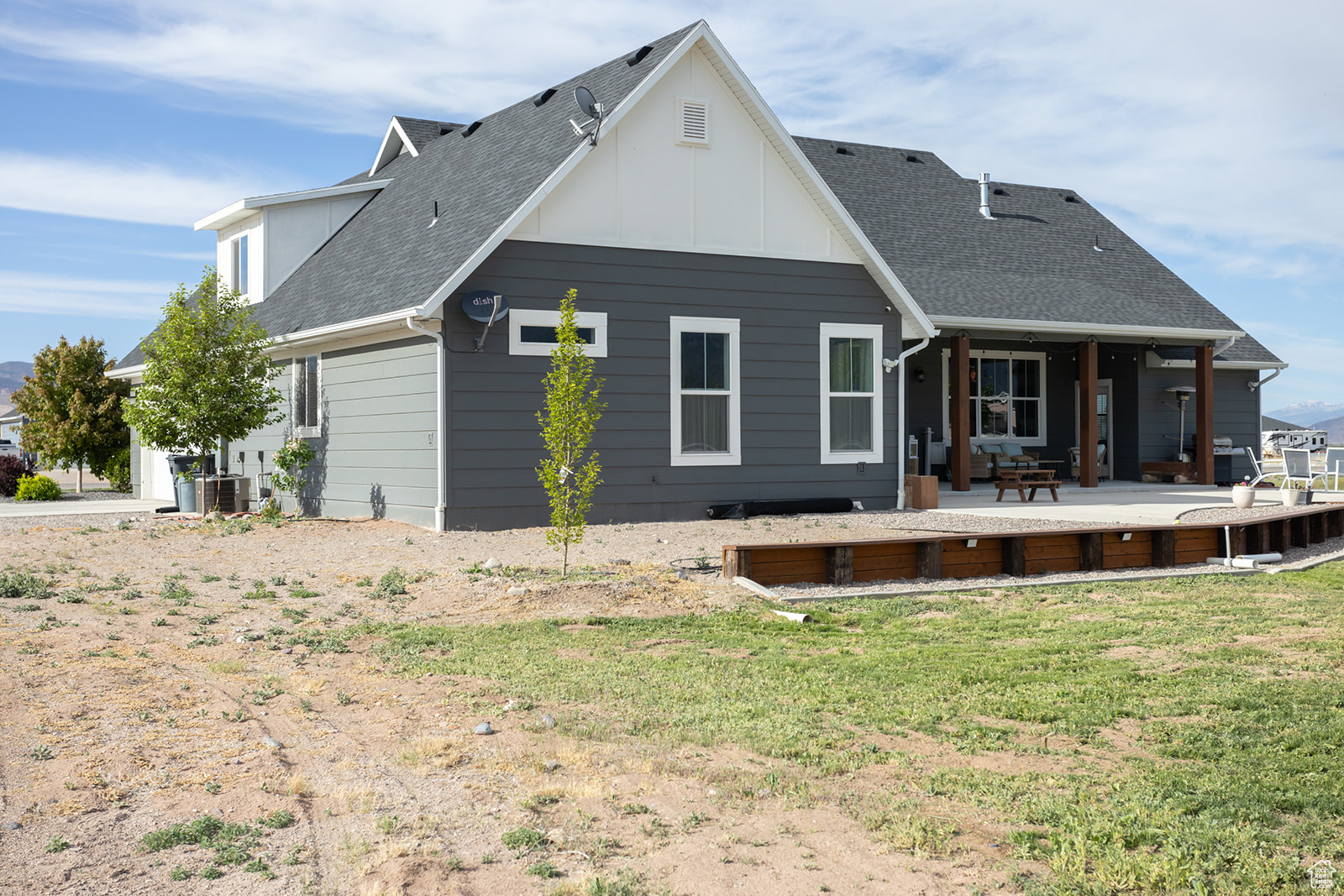 Rear view of house featuring a yard, central AC, and a patio area