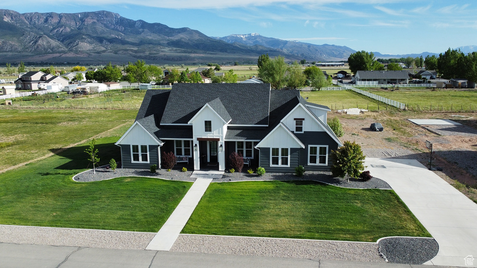 View of front of property with a mountain view and a front lawn