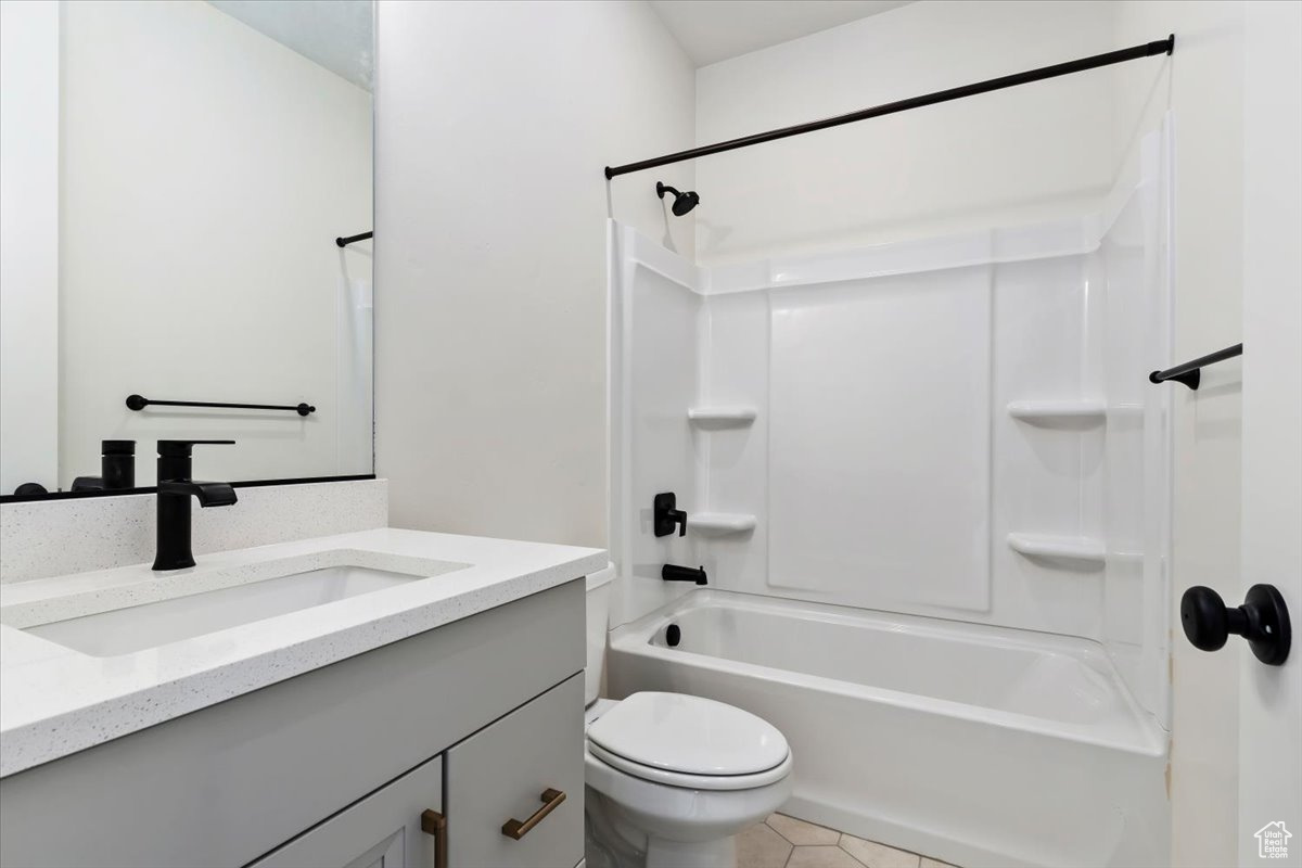 Full bathroom with vanity, tile patterned flooring, shower / bathing tub combination, and toilet