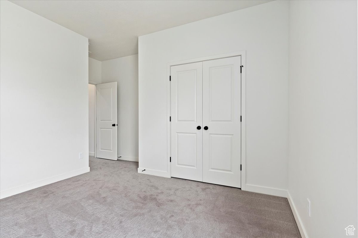 Unfurnished bedroom with carpet and a closet