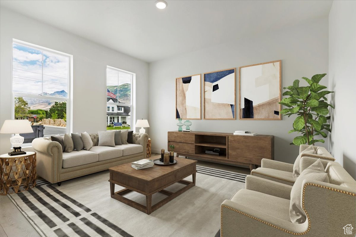 Living room with light hardwood / wood-style flooring and a healthy amount of sunlight