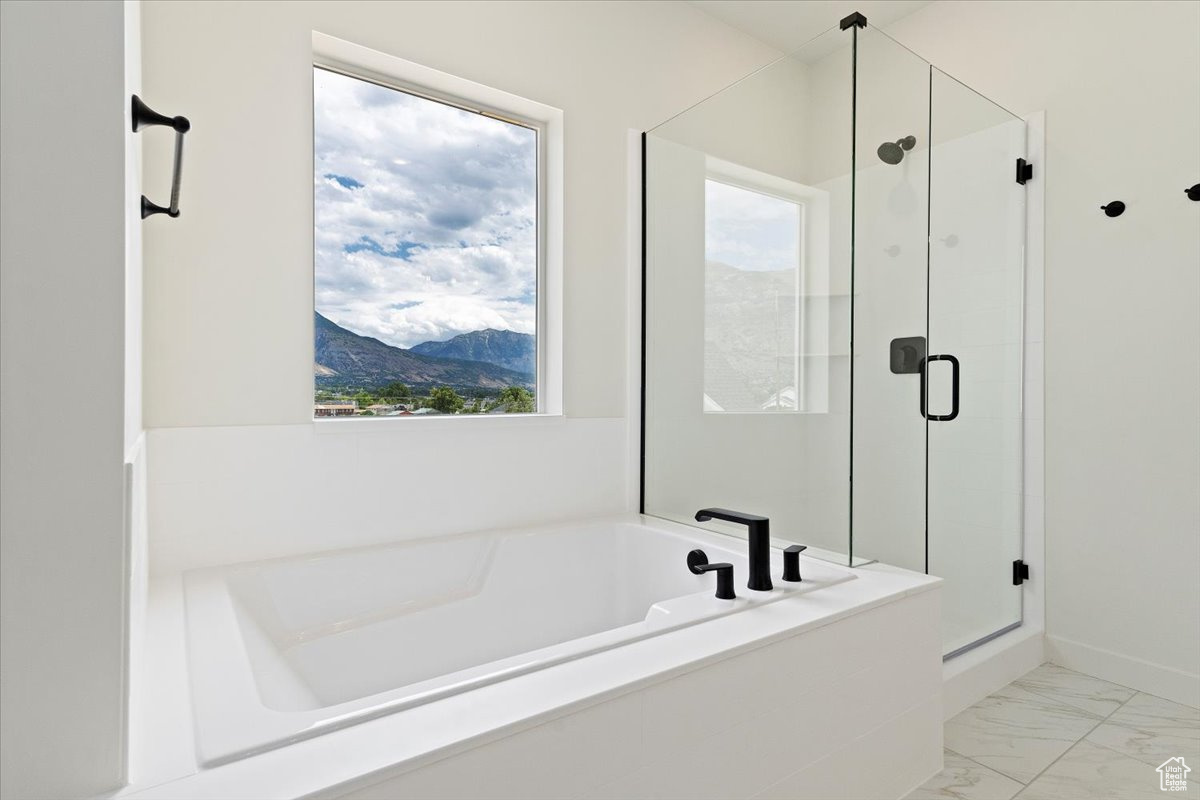 Bathroom with tile patterned flooring, plus walk in shower, and plenty of natural light