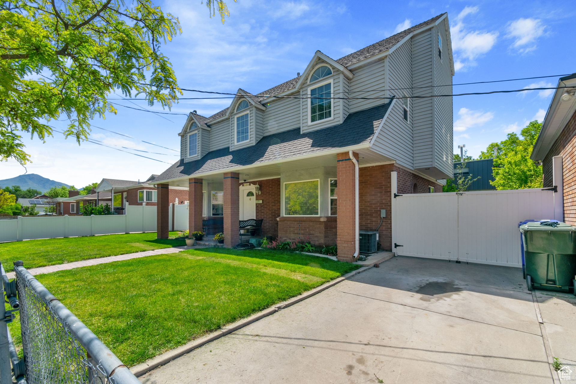 Cape cod home with a front lawn and central AC unit