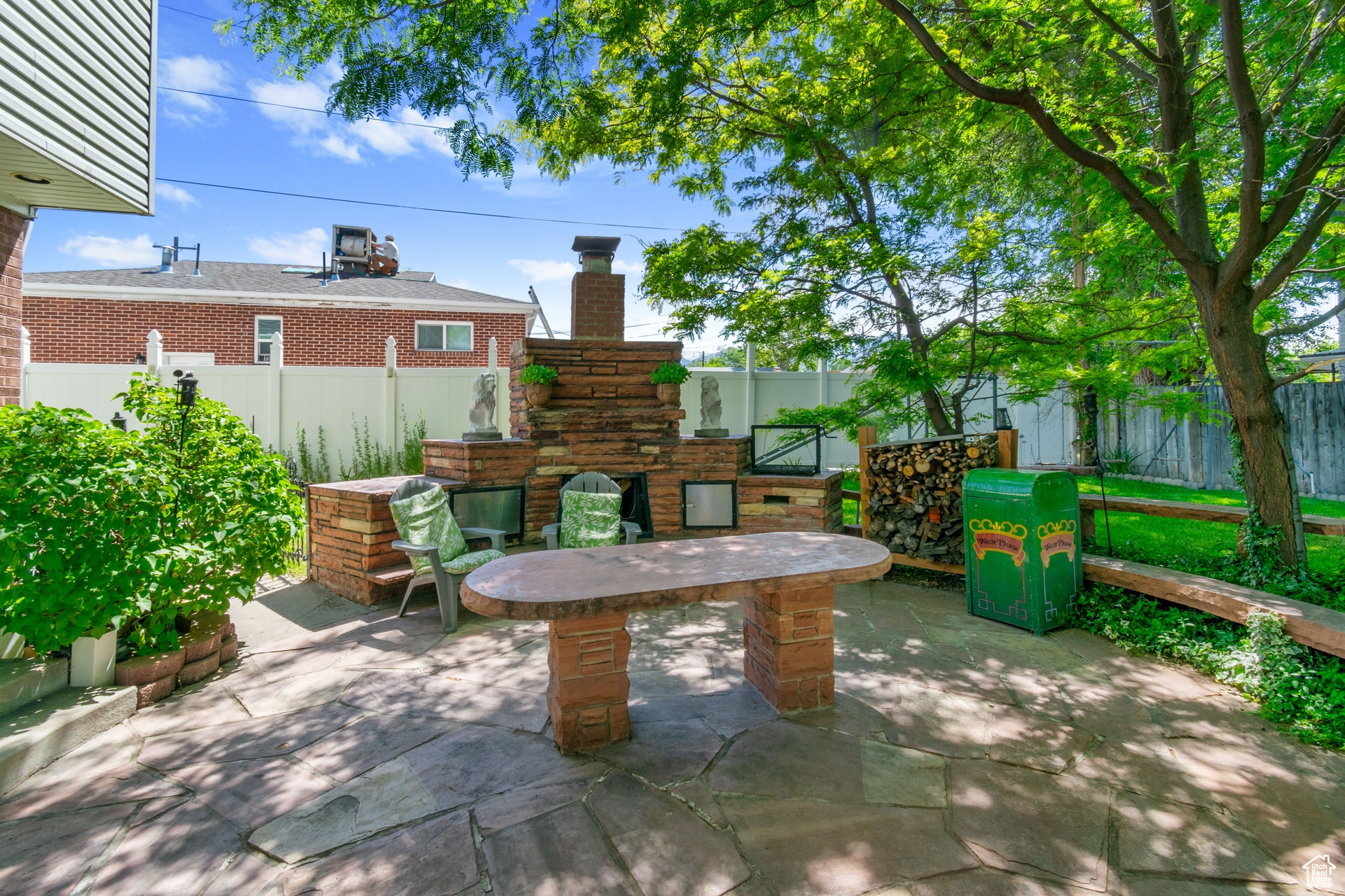 View of terrace featuring an outdoor stone fireplace