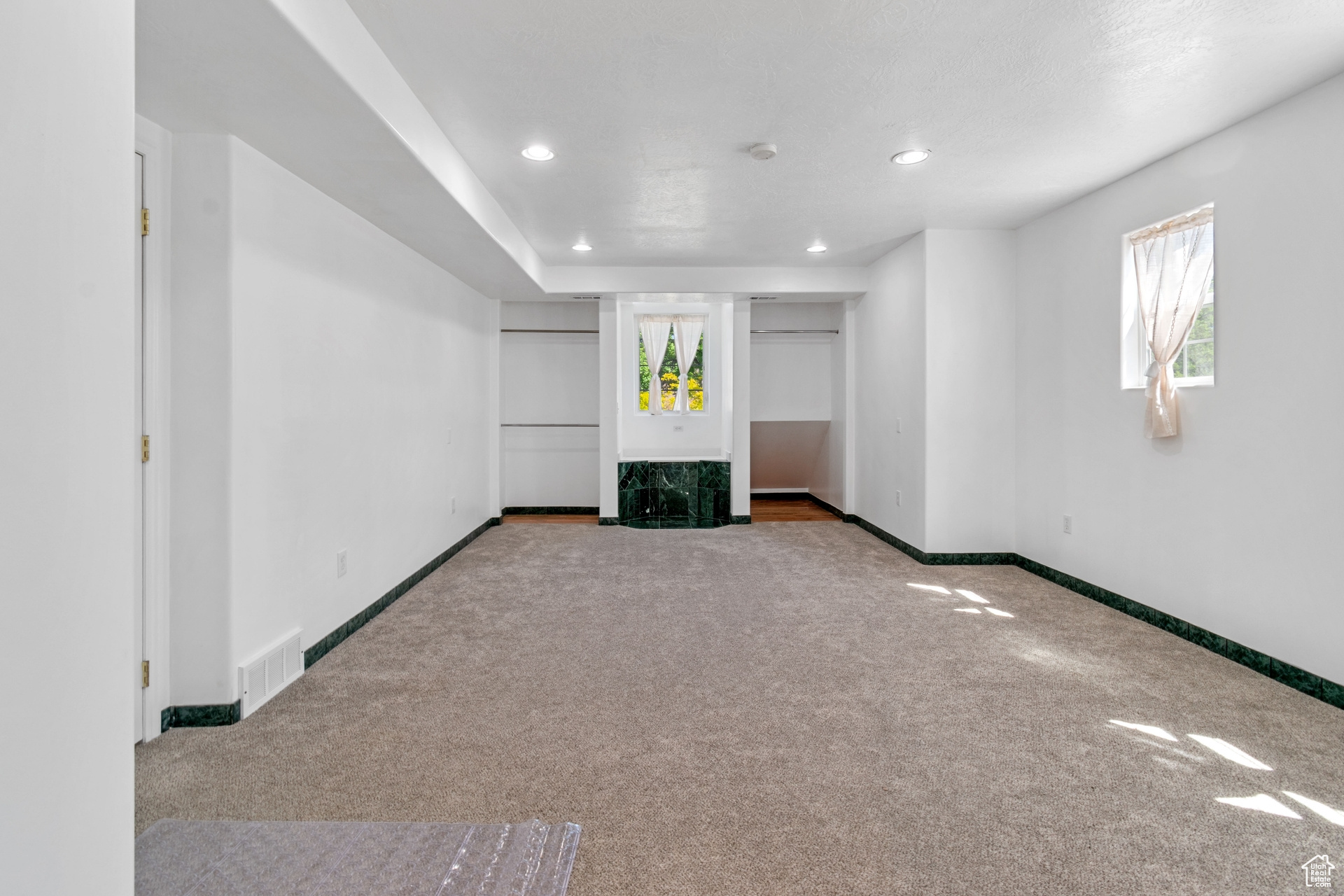 Unfurnished living room with a healthy amount of sunlight and carpet