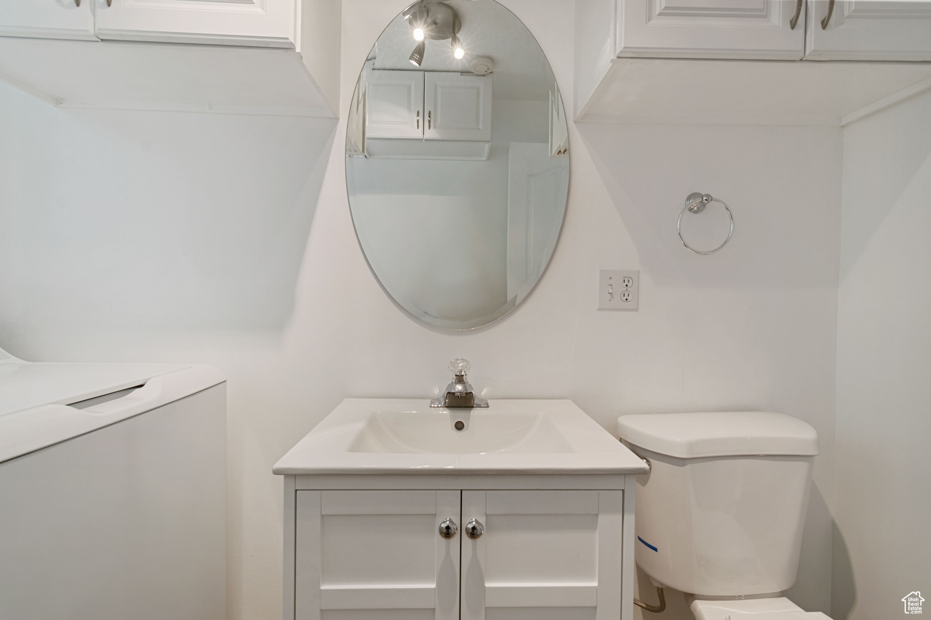 Bathroom featuring washer / dryer, vanity, and toilet