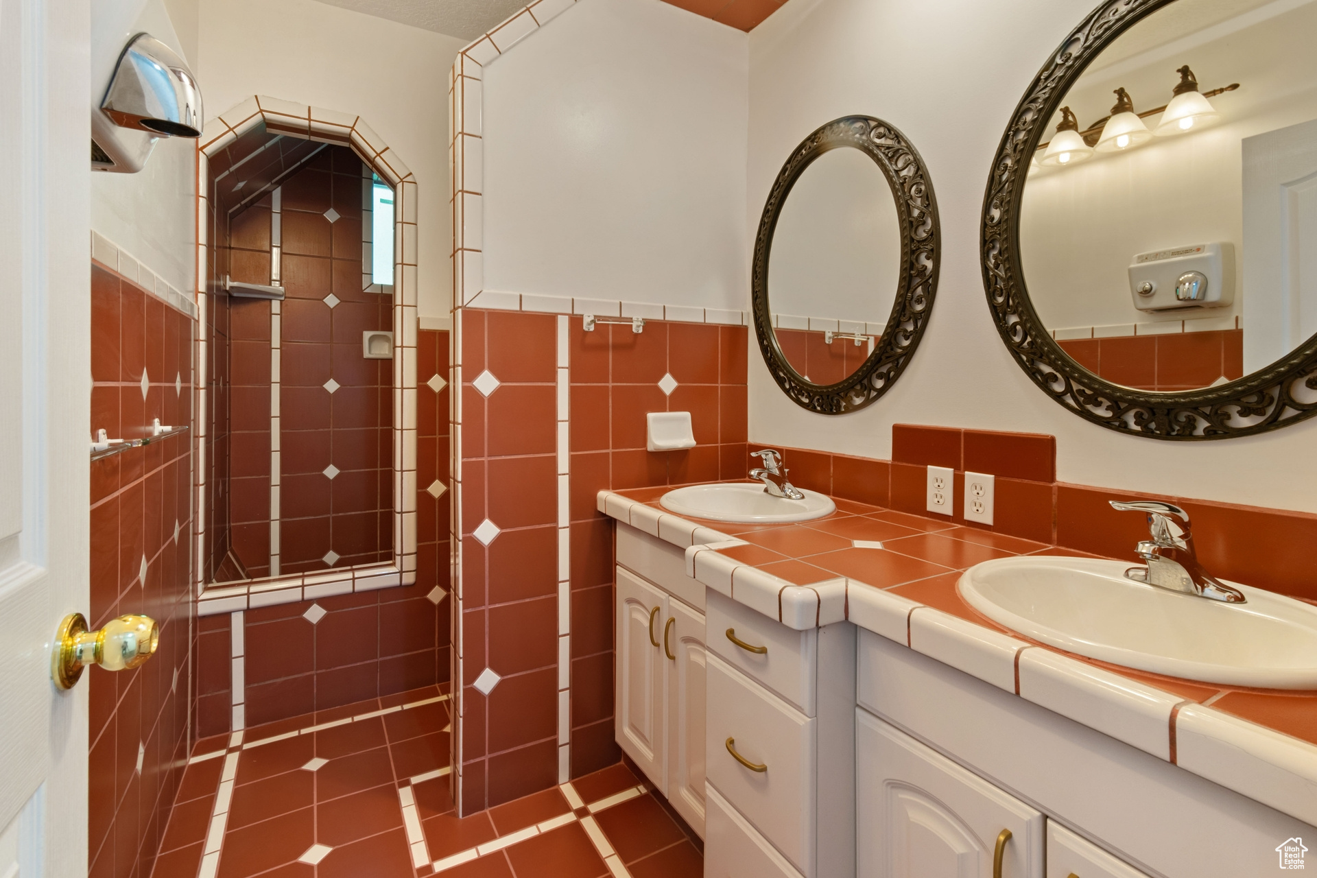 Bathroom with tile flooring, tile walls, tasteful backsplash, large vanity, and dual sinks