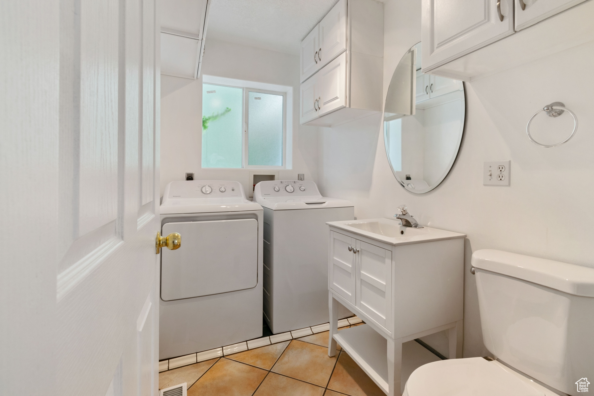 Bathroom with independent washer and dryer, vanity, toilet, and tile floors