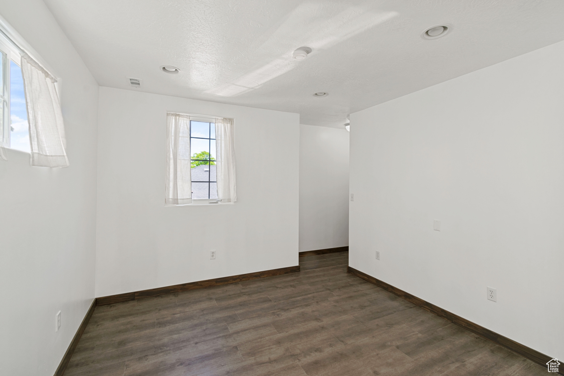 Empty room with dark wood-type flooring