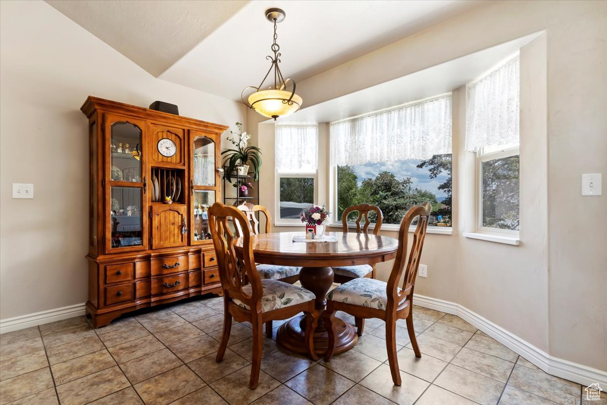 Dining space with vaulted ceiling and tile floors