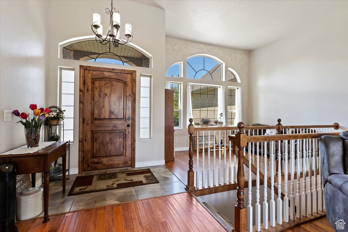 Tiled entryway featuring a high ceiling and a chandelier