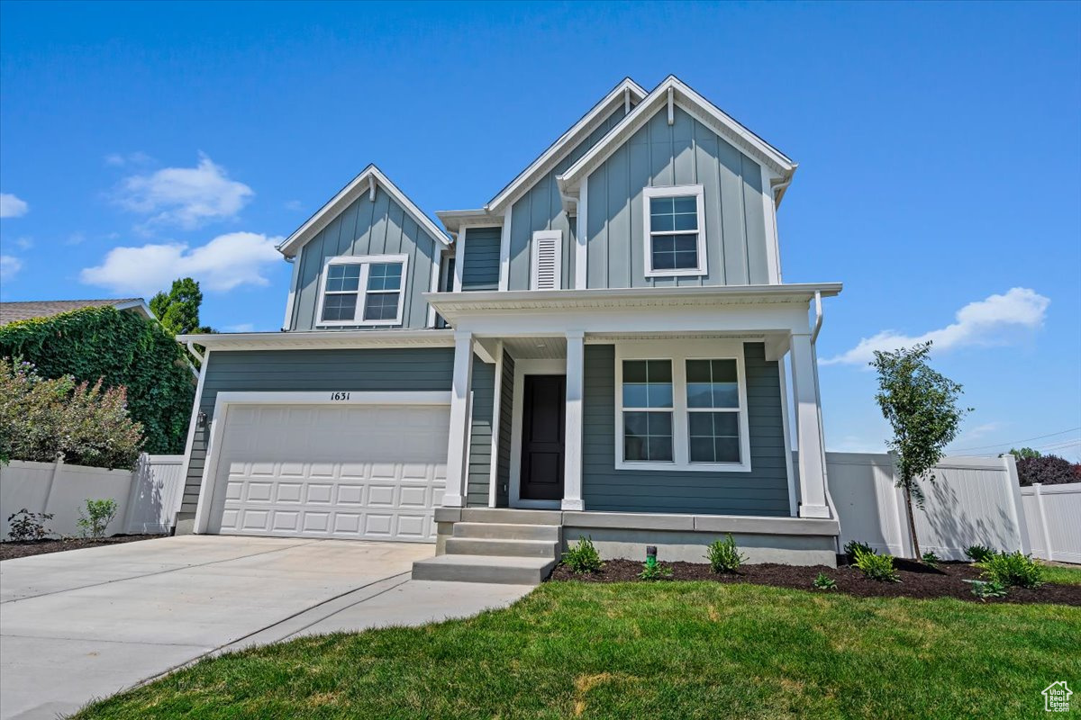 View of front of property with a garage and a front yard