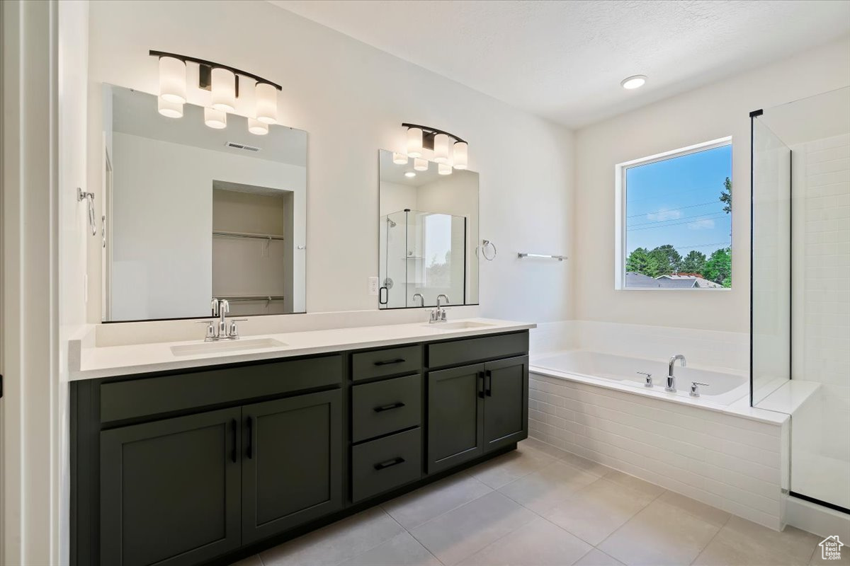 Bathroom with tile patterned floors, plus walk in shower, and dual bowl vanity