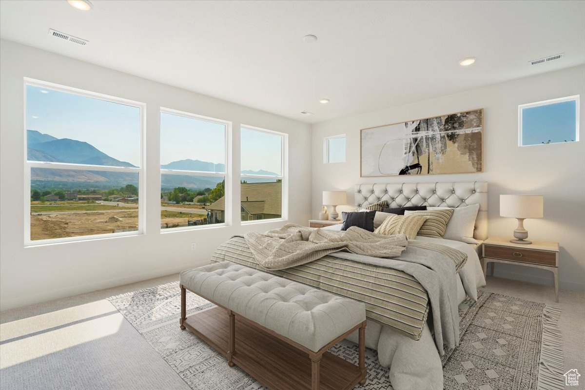 Bedroom featuring a mountain view and light colored carpet