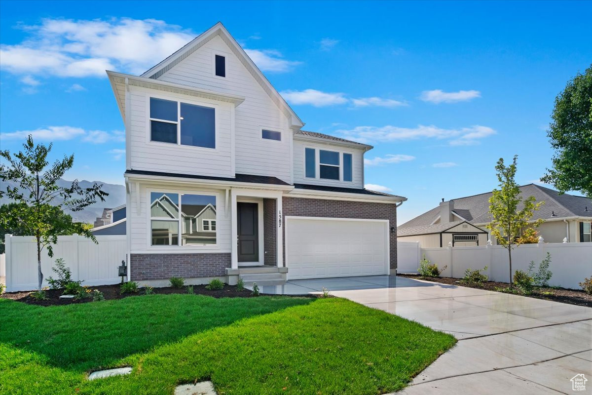 View of front of house with a garage and a front yard