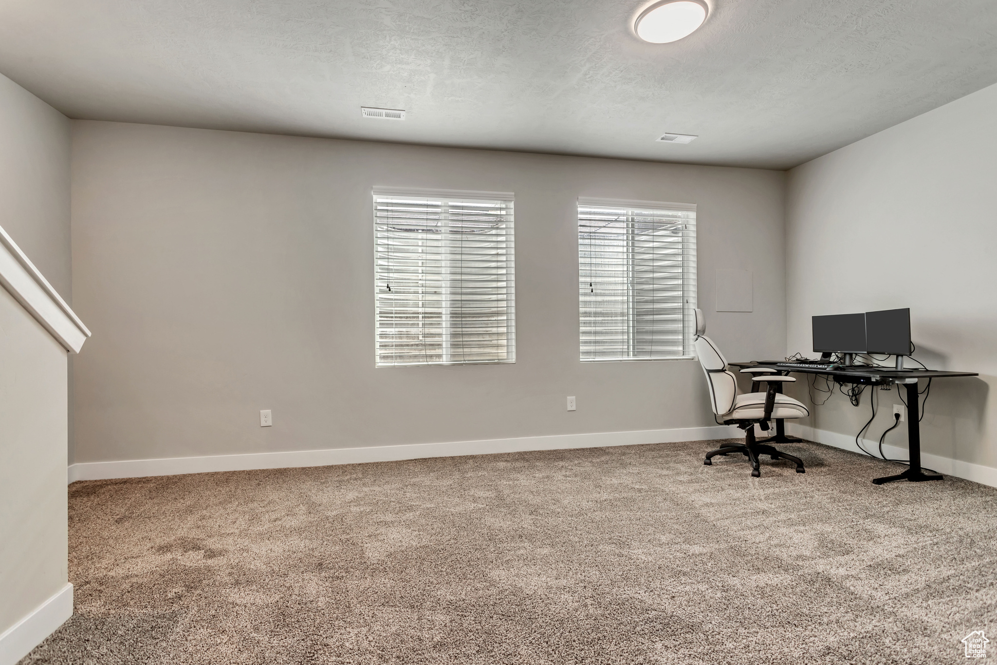 Carpeted office featuring a textured ceiling