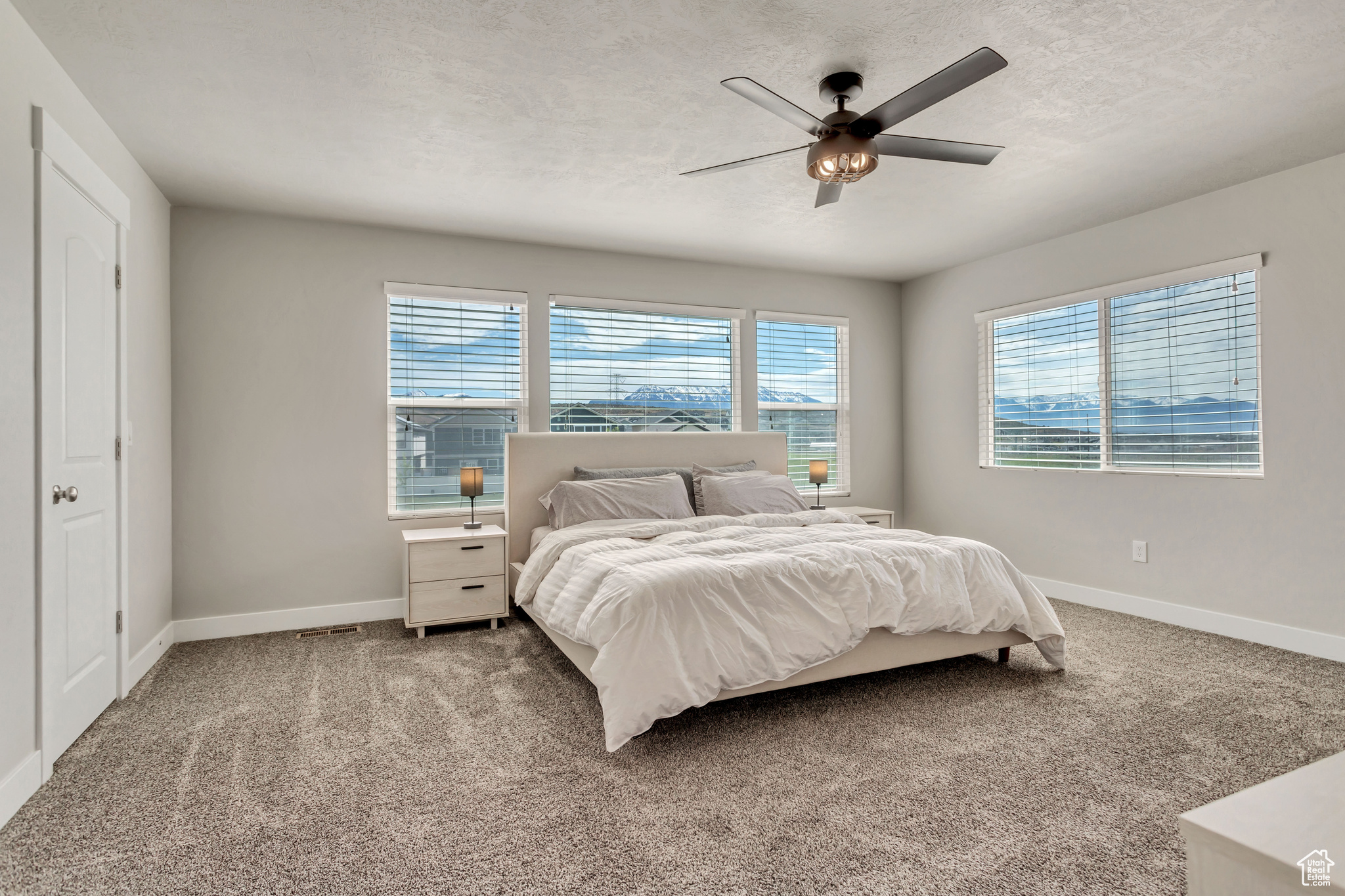 Carpeted bedroom featuring ceiling fan