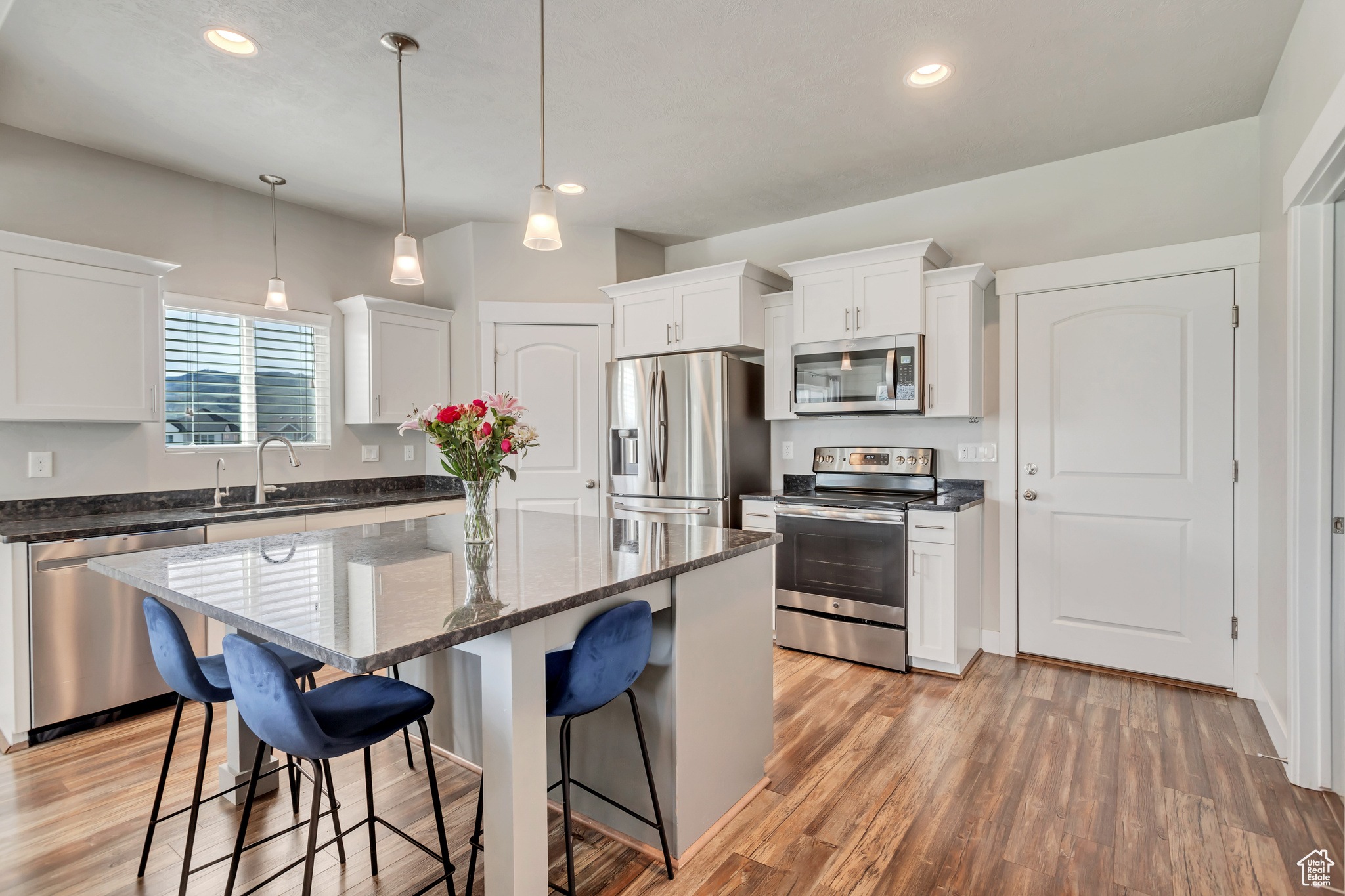 Kitchen featuring stainless steel appliances, light hardwood / wood-style flooring, and a kitchen island