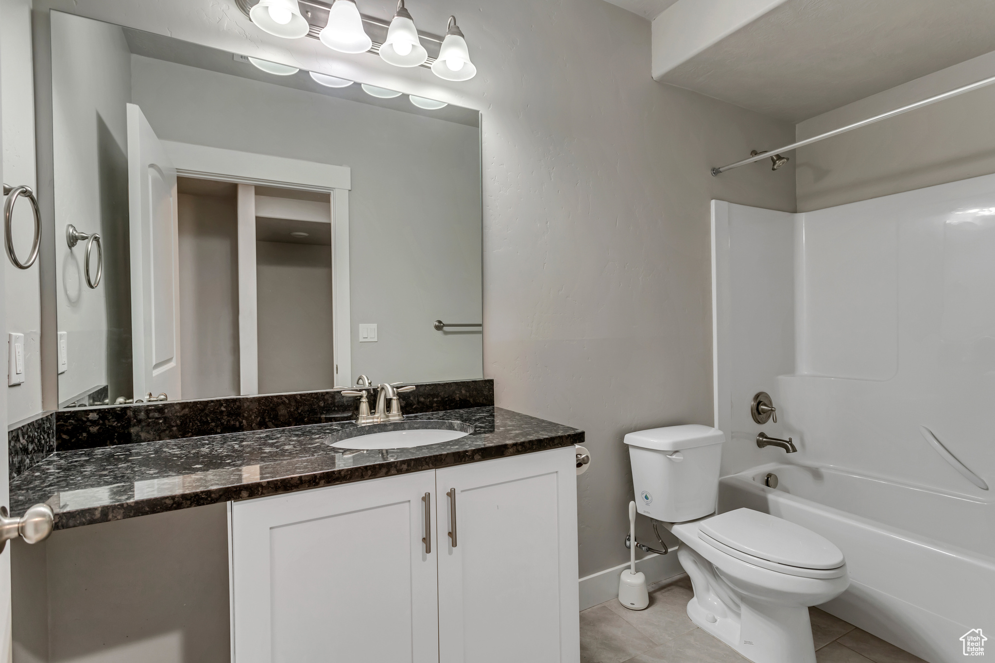 Full bathroom with tile flooring, vanity, toilet, and tub / shower combination