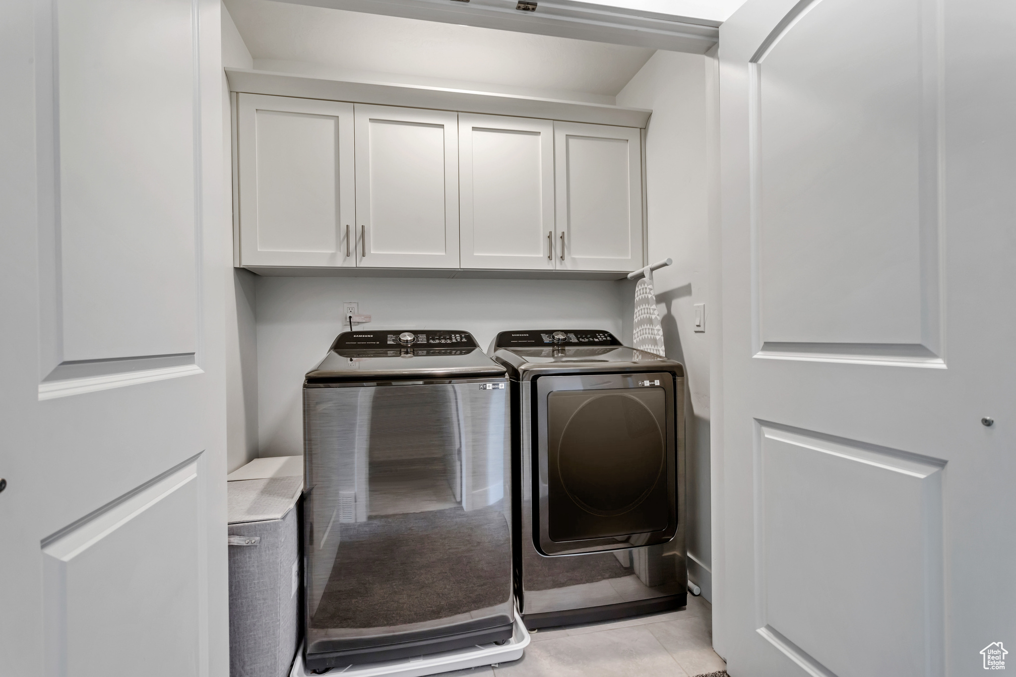 Laundry area featuring cabinets and washer and clothes dryer