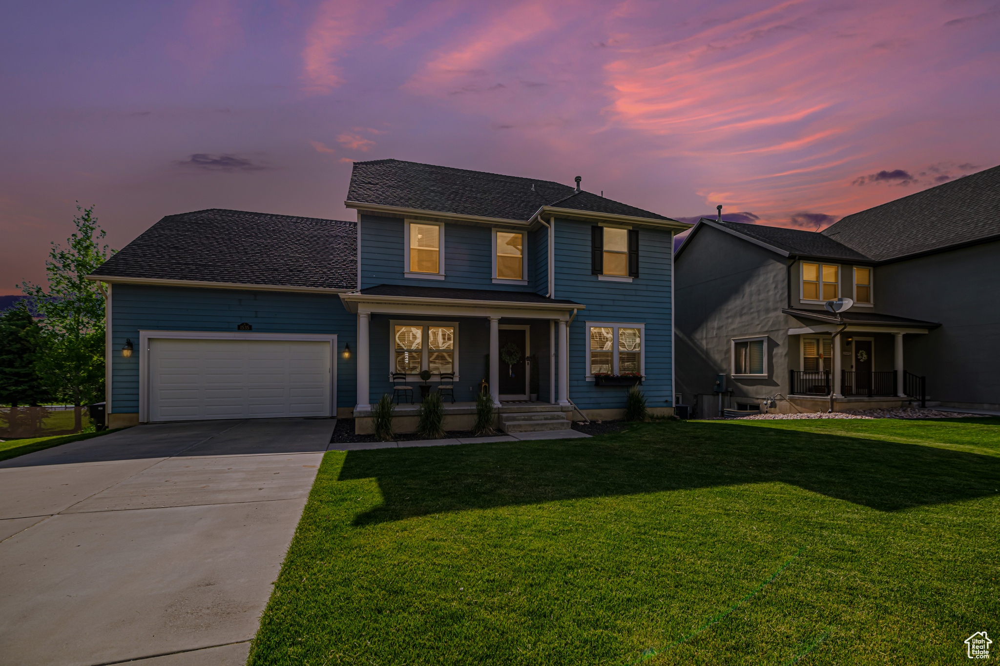 View of front of property with a garage and a yard