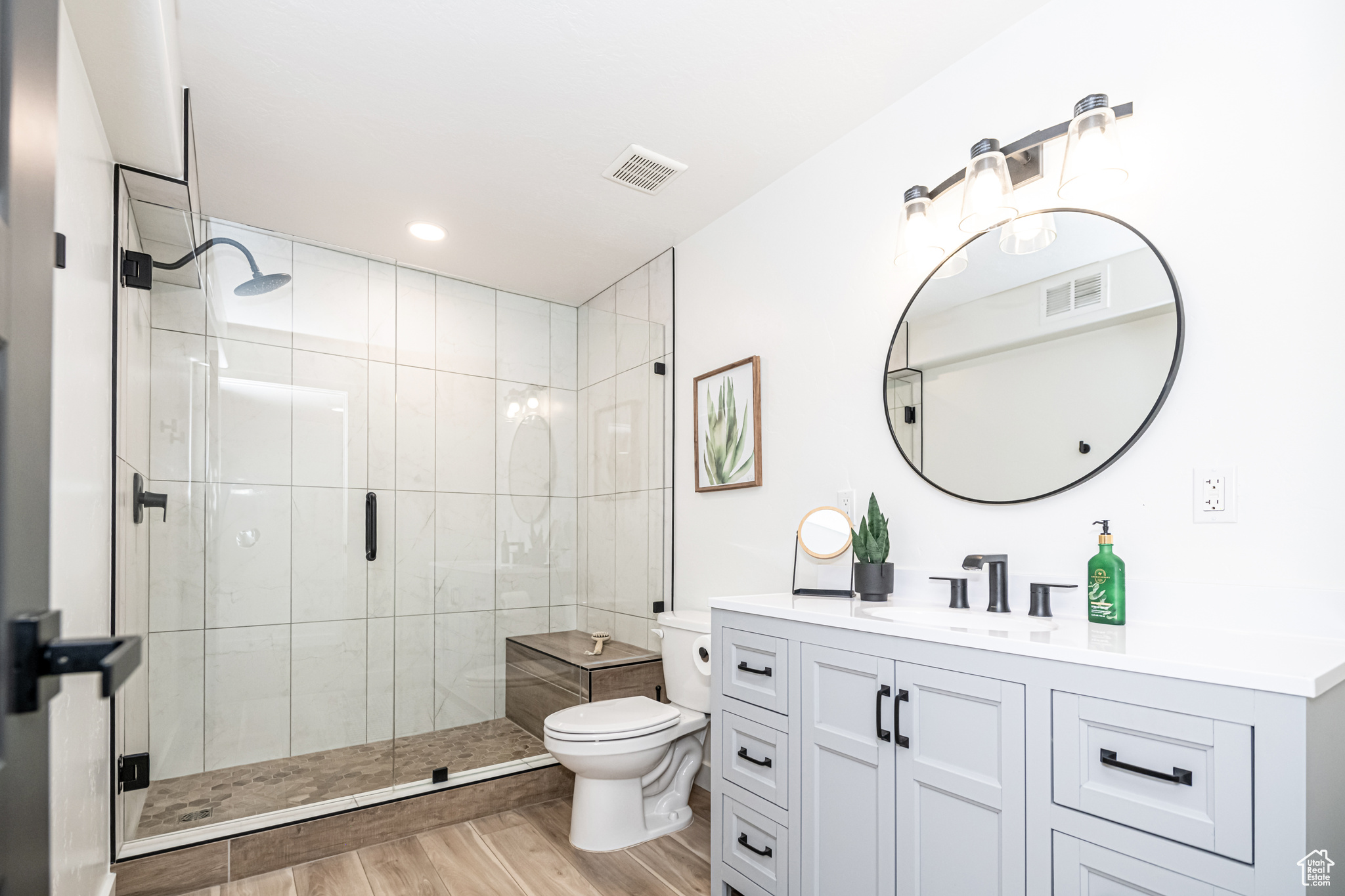 New downstairs bathroom with euro-glass enclosed shower, hardwood and large vanity