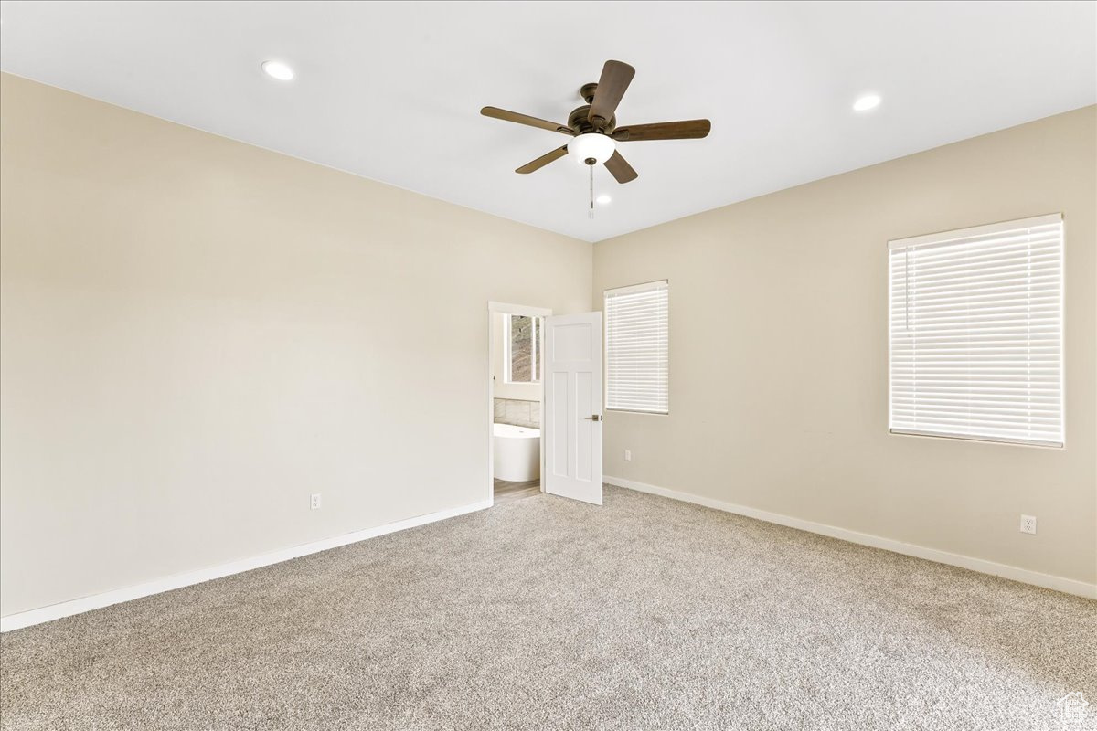 Spare room featuring carpet and ceiling fan