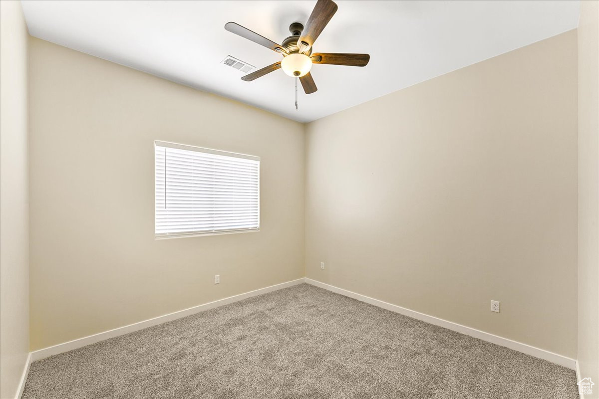 Unfurnished room featuring carpet floors and ceiling fan