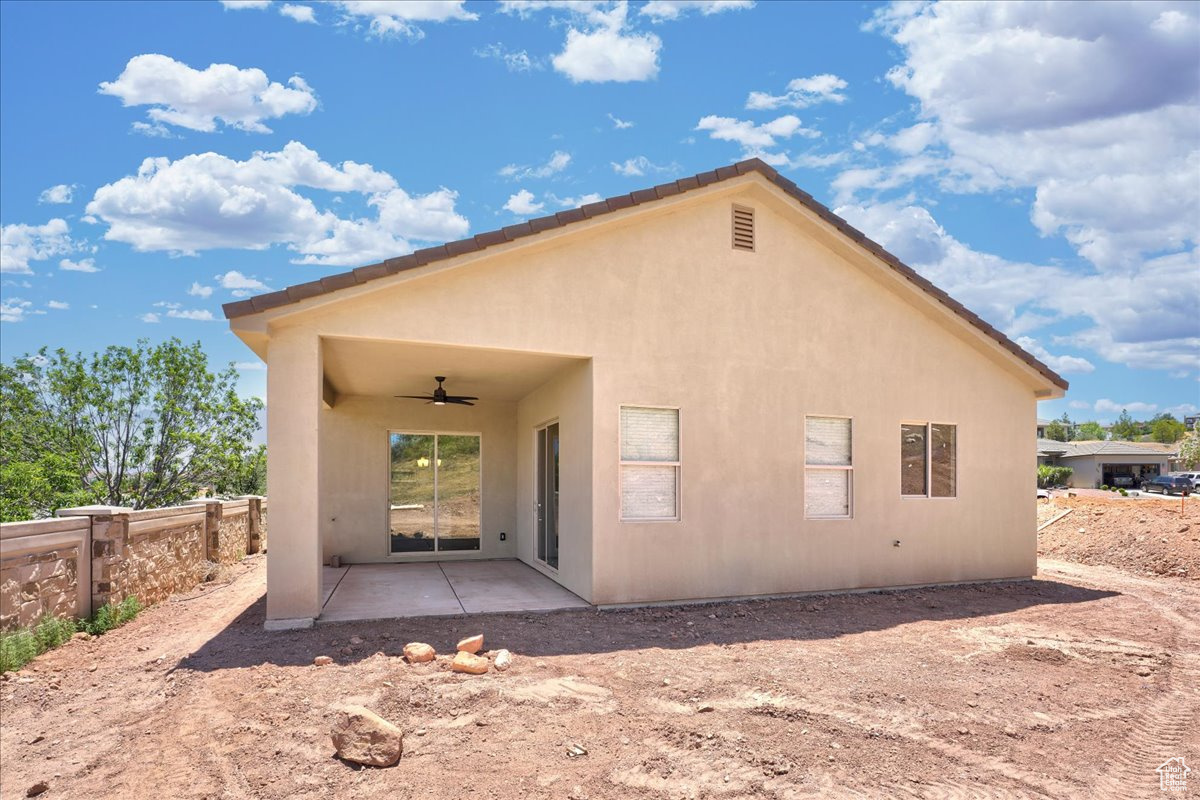 Back of house with ceiling fan and a patio area