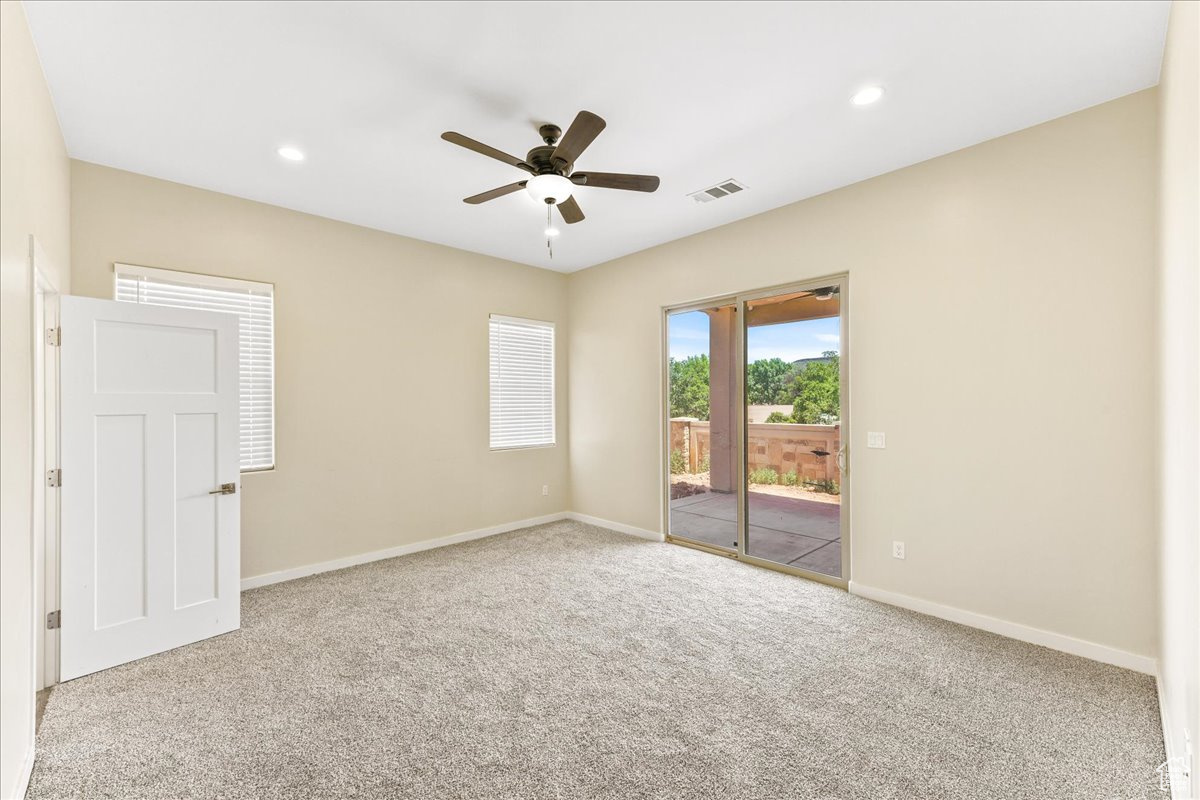 Spare room featuring light colored carpet and ceiling fan