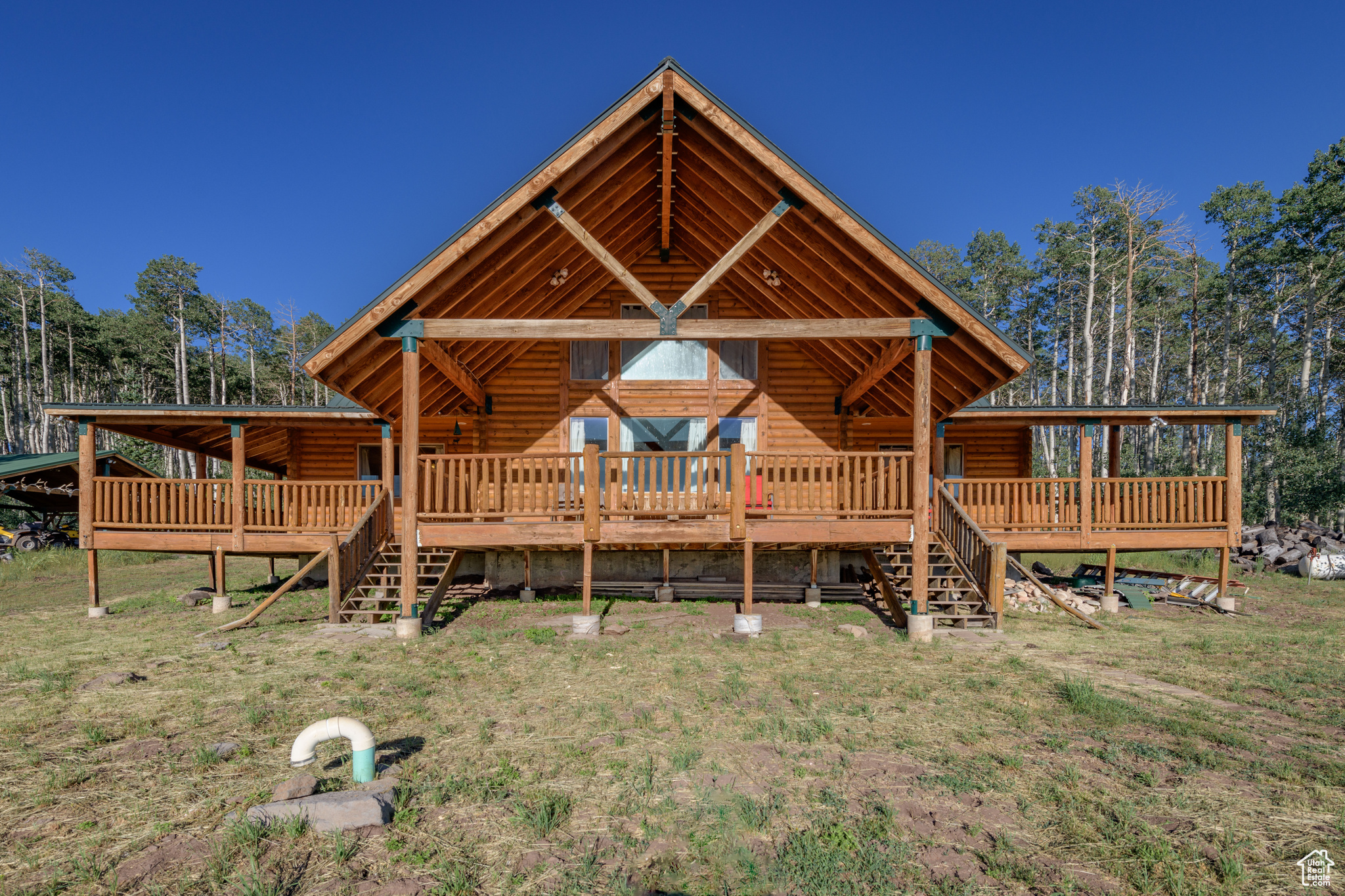 Back of property with a wooden deck and a yard