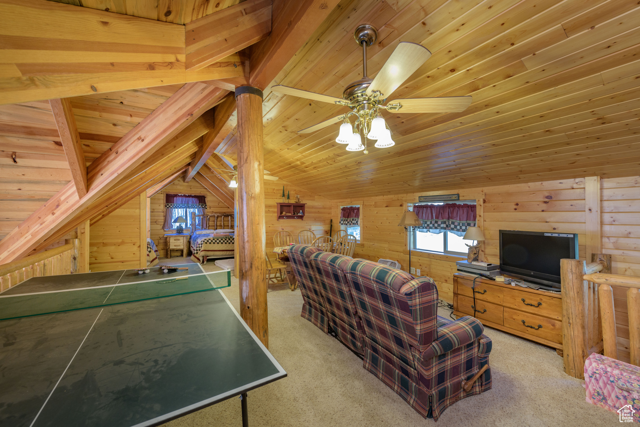 Rec room featuring vaulted ceiling, wood walls, light colored carpet, and wood ceiling