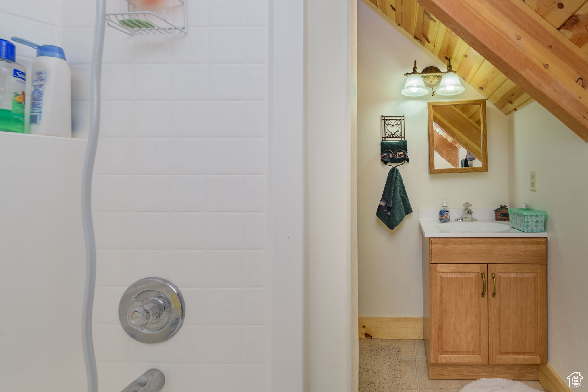 Bathroom with wooden walls, lofted ceiling, and large vanity