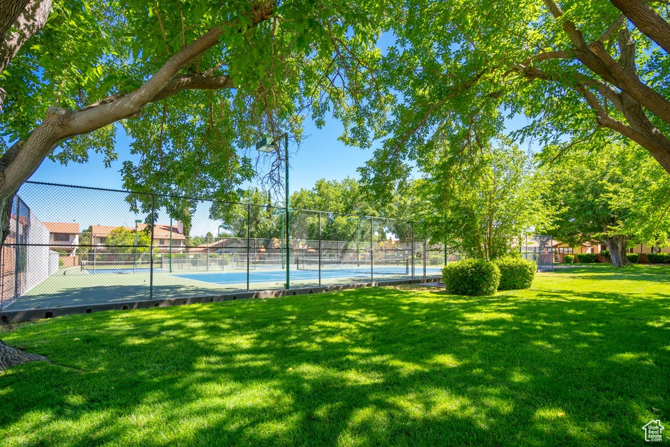 Exterior space with a lawn and tennis court