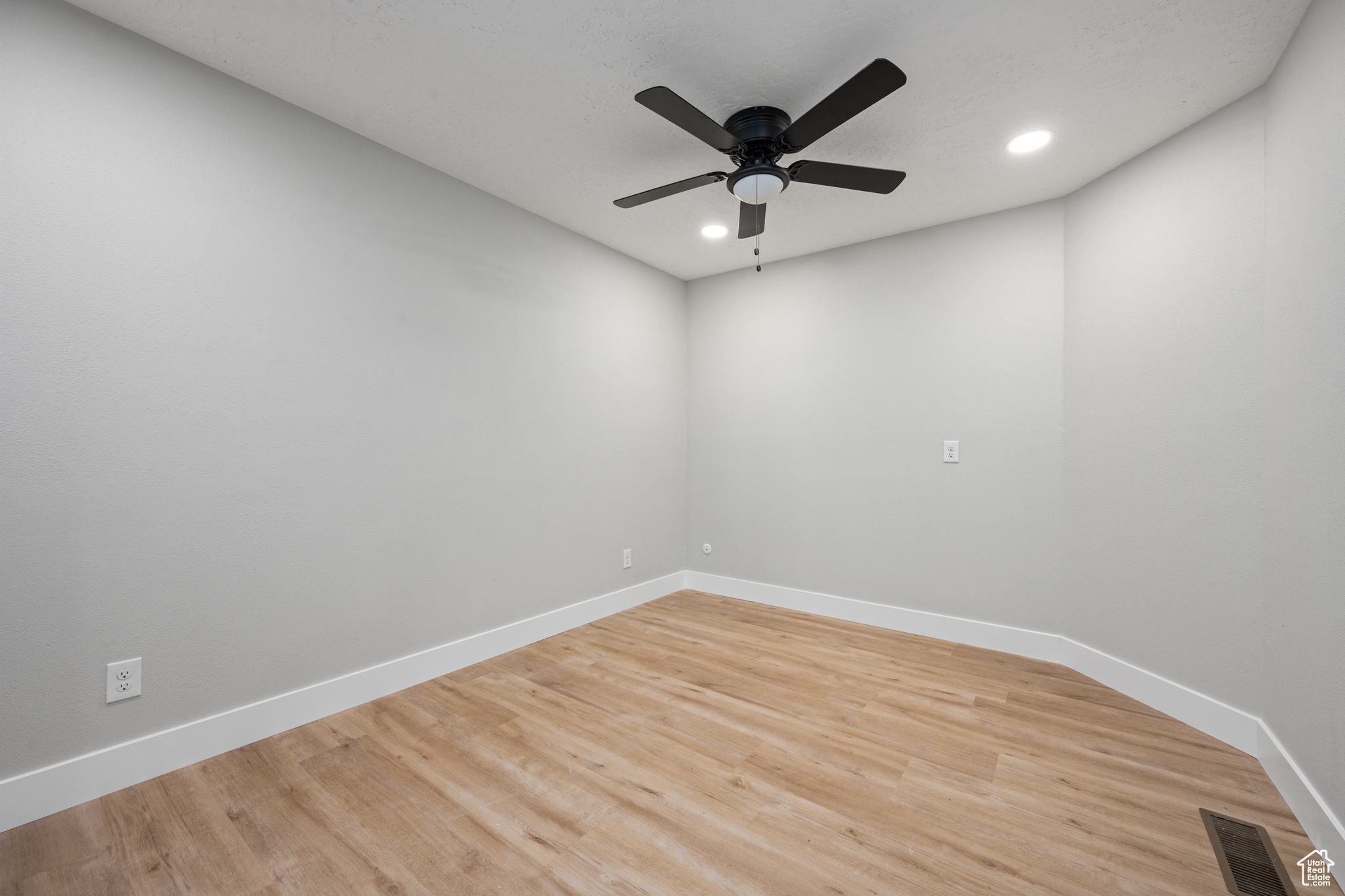 Spare room featuring ceiling fan and light hardwood / wood-style floors