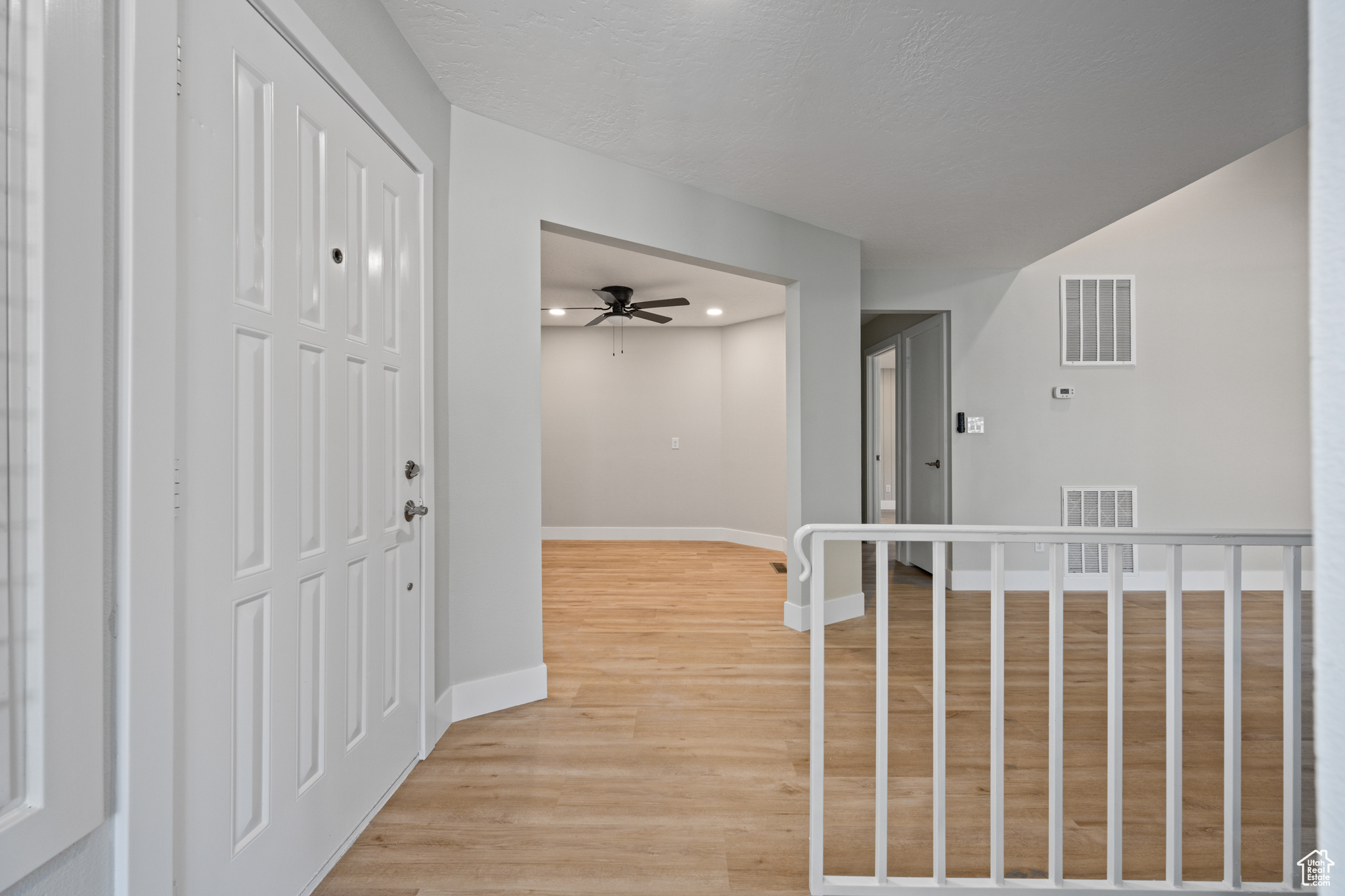 Corridor with light hardwood / wood-style flooring