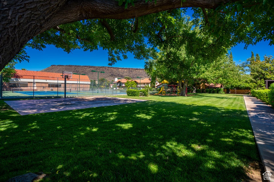 View of yard featuring a playground and tennis court