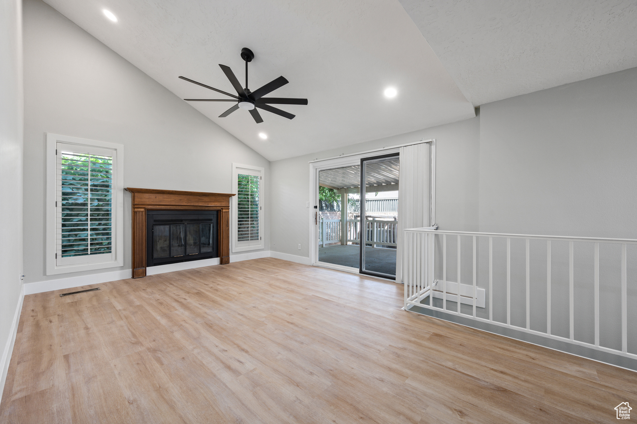 Unfurnished living room with high vaulted ceiling, ceiling fan, and light hardwood / wood-style floors