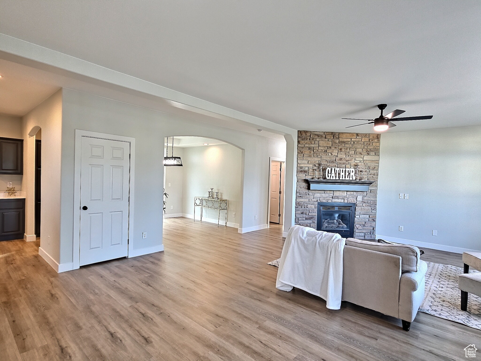 Unfurnished living room featuring ceiling fan, hardwood / wood-style floors, and a fireplace