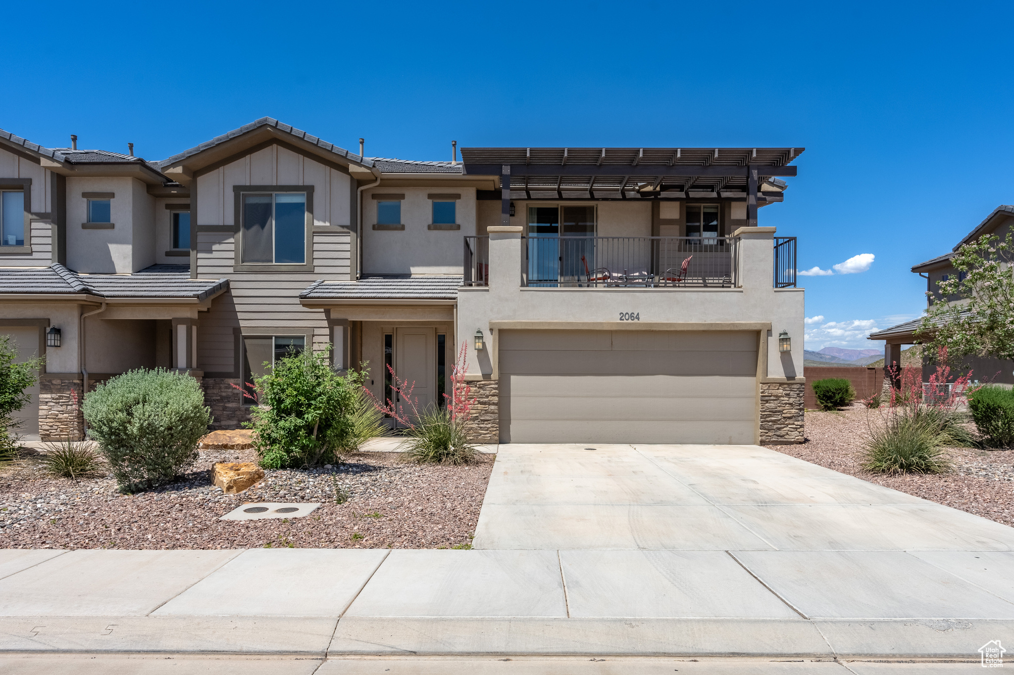 View of front of property featuring a garage and a balcony