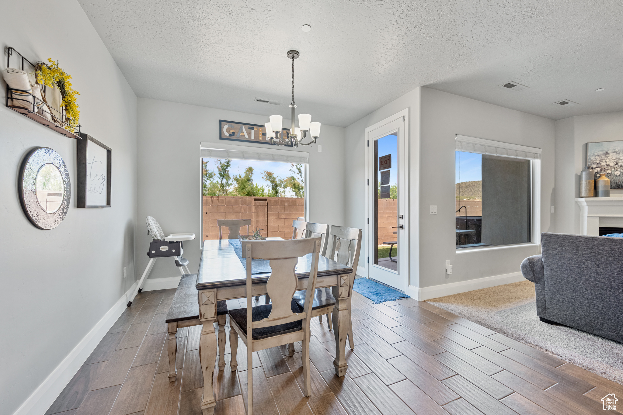 Dining area featuring a notable chandelier, a textured ceiling, and wood-type flooring