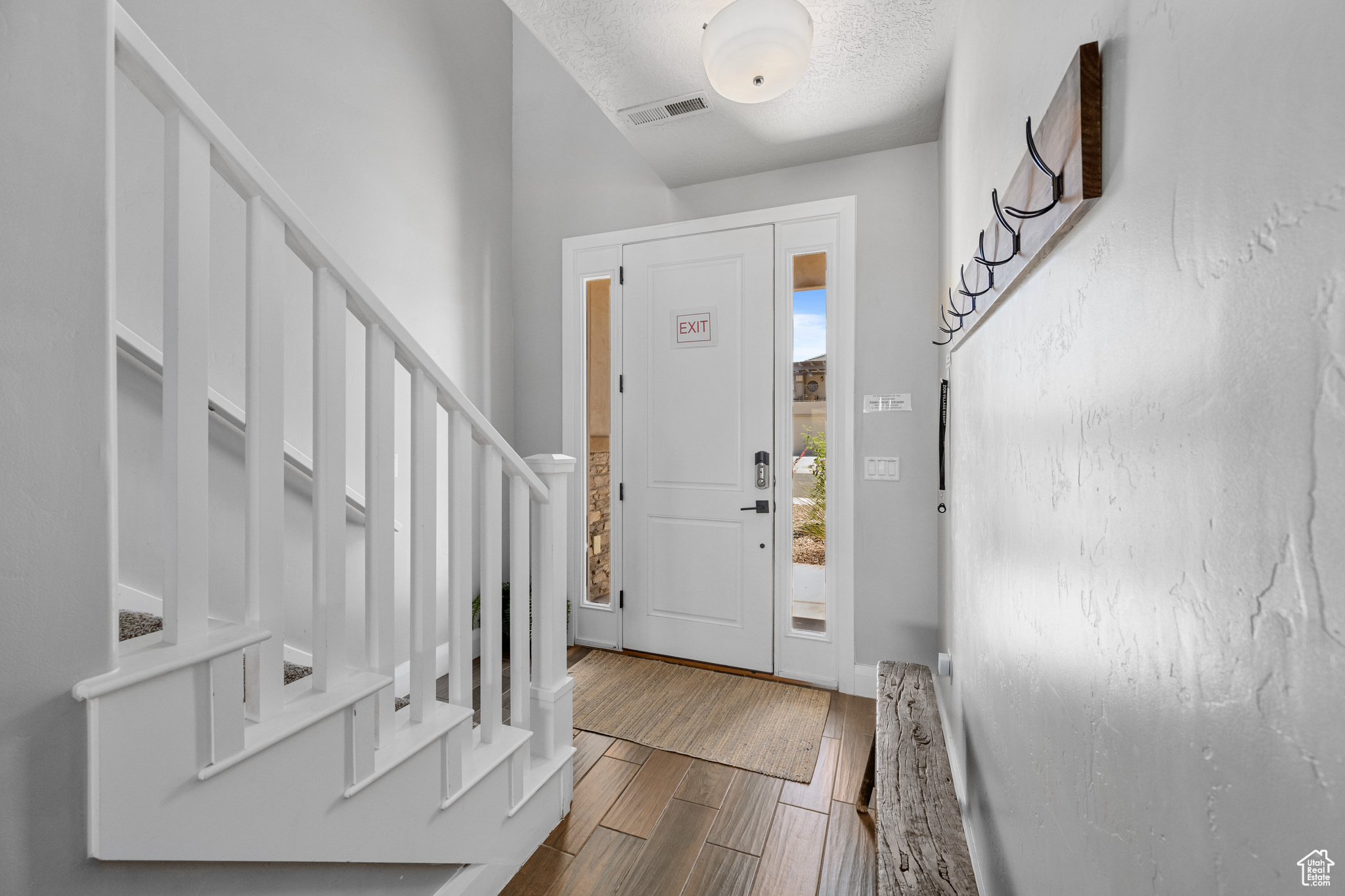 Entrance foyer with wood-type flooring and a textured ceiling